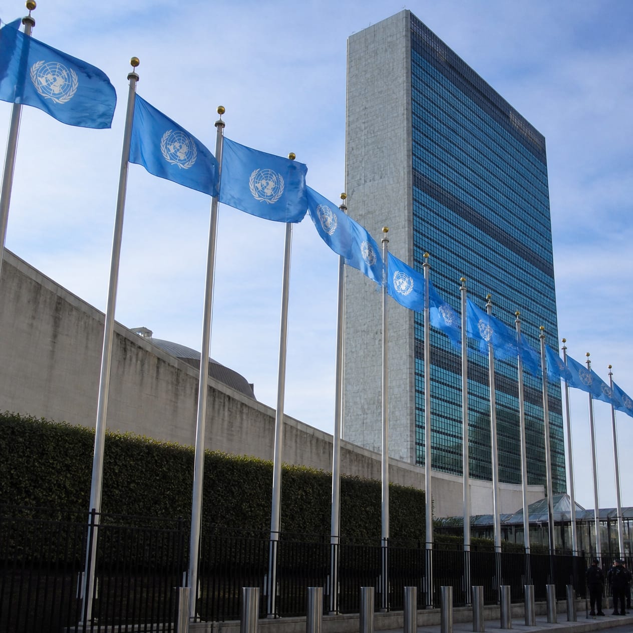 UN Launches Initiative on Military AI: Who Will Control Artificial Intelligence in Future Conflicts? 1 United Nations flags outside UN headquarters, representing the new UNIDIR initiative on military AI