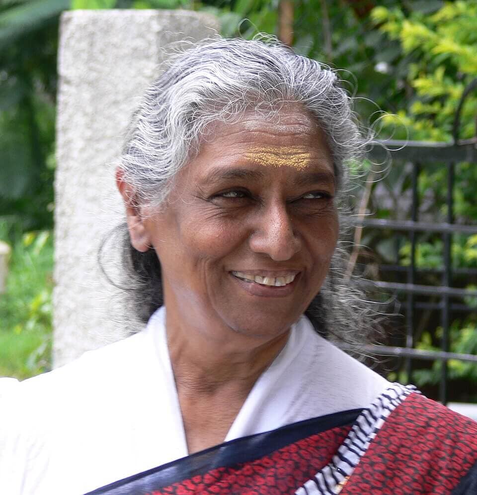 The Quiet Majesty of S. Janaki: A Legend’s Journey from 48,000 Songs to Spiritual Solitude in Mysuru 1 Veteran playback singer S Janaki smiling in a plain white saree, representing her simple and spiritual lifestyle